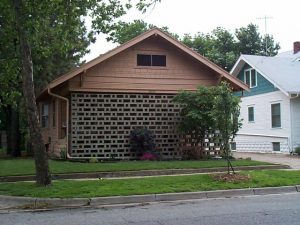 This 1960's masonry screenwall presents an austere face to the street in stark contrast to the open and inviting porch so typical of Craftsman-style bungalows. It is now old enough to be in vogue again.