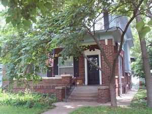 Shutters and a door surround with broken pediment attempted to give the entry of this Prairie-style house a "Colonial" look in the 1960's.