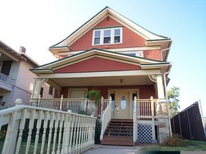 This gable-roofed Prairie-style house has been "Victorianized" with turned stock balusters, porch brackets, a new door with oval light and a bright three-color paint scheme.